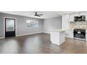 Well-lit living room features gray walls, wood flooring, and an island with white cabinets and speckled countertops at 201 Bedford St # 79, Sun City Center, FL 33573