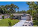 Charming single-story home with manicured lawn, tile roof, and attached garage at 2123 Indigo Dr, Clearwater, FL 33763
