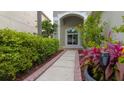 Inviting walkway to the home's entrance with lush landscaping and a charming front door at 25435 Bruford Blvd, Land O Lakes, FL 34639