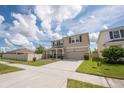 Charming two-story home with a manicured lawn, covered front porch, and a two-car garage at 3052 Living Coral Dr, Odessa, FL 33556