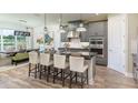 Modern kitchen with stainless steel appliances, a large island, and stylish pendant lighting at 35154 Emberview Dr, Zephyrhills, FL 33541