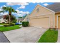 Exterior view of a charming beige home, featuring lush landscaping and an attached garage at 3602 Pine Knot Dr # 0, Valrico, FL 33596
