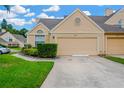 Beige home exterior featuring an attached garage, well-kept lawn, and blue sky backdrop at 3602 Pine Knot Dr # 0, Valrico, FL 33596