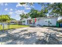 Exterior view of a cozy home with a front porch, a well-kept lawn, and a fenced yard at 3809 N 14Th St, Tampa, FL 33603