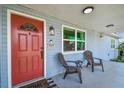 Close-up of a charming front porch with seating and a vibrant red front door at 3809 N 14Th St, Tampa, FL 33603