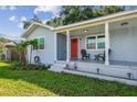 Inviting front porch with chairs, a bright red door, and manicured landscaping at 3809 N 14Th St, Tampa, FL 33603