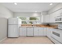 The kitchen has white appliances, plentiful cabinetry, and a sink beneath a sunlit window at 3901 17Th N Ave, St Petersburg, FL 33713