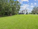 Expansive backyard featuring lush lawn and mature trees creating a private and serene outdoor space at 422 Cypress View Dr, Oldsmar, FL 34677