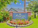 Entrance to deed restricted Cypress Lakes community featuring colorful flower beds and mature landscaping at 422 Cypress View Dr, Oldsmar, FL 34677