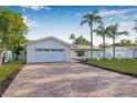 Charming home with a well manicured lawn and brick driveway and front entrance and attractive landscaping at 4495 Clearwater Harbor S Dr, Largo, FL 33770