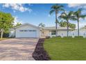 Charming home with a well manicured lawn and brick driveway and front entrance and attractive landscaping at 4495 Clearwater Harbor S Dr, Largo, FL 33770