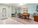 Bright dining room features a classic chandelier, window, and a neutral carpet at 5423 Windbrush Dr, Tampa, FL 33625