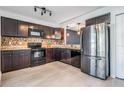 This is a spacious kitchen with stainless steel appliances, granite countertops, and decorative mosaic tile backsplash at 6 Harbor Cove St, Safety Harbor, FL 34695