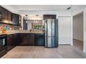 Bright kitchen with stainless steel refrigerator, granite counters, mosaic backsplash, and tile floors at 6 Harbor Cove St, Safety Harbor, FL 34695