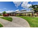 Inviting home with lush greenery, a lamp post, and a circular concrete driveway at 604 Knollwood Dr, Largo, FL 33770