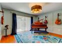 Stylish music room featuring an upright piano, hardwood floors, and custom paint at 604 Knollwood Dr, Largo, FL 33770