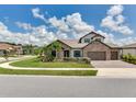 Attractive stone home featuring a lush lawn, palm trees and a paved driveway at 6057 Marsh Trail Dr, Odessa, FL 33556