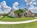Landscaped home with stone accents, lush lawn and a well-maintained sidewalk at 6057 Marsh Trail Dr, Odessa, FL 33556
