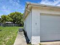 Home exterior featuring a one-car garage, well-maintained siding, and a grassy backyard at 9505 Marlinton Ln, Port Richey, FL 34668