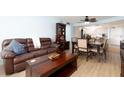 Comfortable living and dining area with a brown leather sofa, dark wood furniture, and an adjacent kitchen at 11000 Gulf Blvd # 1004, Treasure Island, FL 33706