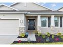 Attractive home entrance with a black front door and stone column accents at 11295 Timber Grove Ln, Brooksville, FL 34613
