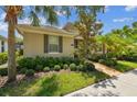 Beautiful home featuring tropical landscaping, a brick path, and a welcoming exterior at 11317 Wickersley Pl, Tampa, FL 33625