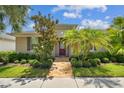 Charming home showcasing lush landscaping, a brick walkway, and a cozy covered entry at 11317 Wickersley Pl, Tampa, FL 33625