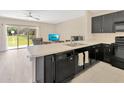 Modern kitchen showcasing black appliances, bright countertops, and a sliding door to the backyard at 12710 Buffalo Run Drive, Gibsonton, FL 33534