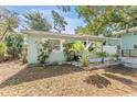 Well-maintained home showing a covered porch, tidy landscaping with palms, and light-green siding at 1327 S Michigan Ave, Clearwater, FL 33756