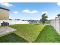 Spacious backyard with a well-maintained lawn and a partial view of a serene pond at 13324 Willow Bluestar Loop, Riverview, FL 33579