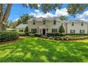 Charming two-story home featuring manicured lawn, lush landscaping, and classic American curb appeal at 1628 Long Bow Ln, Clearwater, FL 33764