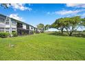 The condo backyard featuring lush green space with mature trees extending to the golf course at 2049 Skimmer W Ct # 311, Clearwater, FL 33762