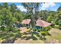 Aerial view of a single-story home with mature trees, a well-manicured lawn, and beautiful landscaping at 2515 Pemberton Creek Dr, Seffner, FL 33584