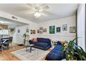 Bright living room featuring hardwood floors and comfortable blue couches at 3335 Fox Hunt Dr, Palm Harbor, FL 34683