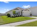 Attractive single-Gathering home featuring lush green lawn, well-kept landscaping, and two-car garage at 33369 Hamilton Hill Ln, Wesley Chapel, FL 33545