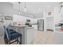 Spacious kitchen boasts modern appliances, white cabinetry, and a breakfast bar for casual dining at 34811 Arbor Green Pl, Zephyrhills, FL 33541