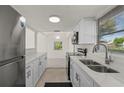 Well-lit, updated kitchen with stainless steel appliances, white cabinets, and a double sink at 3513 Syracuse St, Port Charlotte, FL 33952