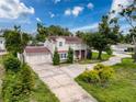Lovely home showcasing a sprawling driveway, lush trees, and an attached two-car garage at 425 49Th N St, St Petersburg, FL 33710