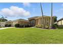Charming single-story home with arched windows, lush landscaping, and a spacious driveway at 4428 Gevalia Dr, Brooksville, FL 34604