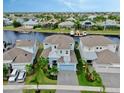 Aerial view of a blue two-story home on a canal with a private dock and lush landscaping at 5307 Wishing Arch Dr, Apollo Beach, FL 33572