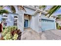 Home exterior featuring a light blue front door, stone address numbers, and a two-car garage at 5307 Wishing Arch Dr, Apollo Beach, FL 33572