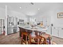 Bright kitchen featuring white cabinets, stainless steel appliances, and a functional center island with seating at 5422 Braddock Dr, Zephyrhills, FL 33541