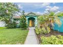A walkway leads to the welcoming yellow double-door entrance of the charming blue home at 7046 Frascati Loop, Wesley Chapel, FL 33544