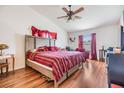 Spacious bedroom with hardwood floors, a large bed, and a ceiling fan at 7046 Frascati Loop, Wesley Chapel, FL 33544