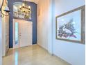 Bright foyer featuring tiled floors, a decorative painting, and an overhead transom window at 7254 Parkersburg Dr, Wesley Chapel, FL 33545