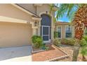 Home's exterior showcasing its appealing facade, including the front door, garage, and tidy landscaping at 7254 Parkersburg Dr, Wesley Chapel, FL 33545