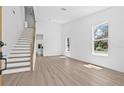 Open living space boasting wood floors, a staircase, and large windows at 7617 Alvina St, Tampa, FL 33625