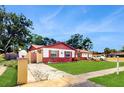 Charming single Gathering home with well-maintained lawn, eye-catching exterior details and manicured landscape at 7710 Jackson Springs Rd, Tampa, FL 33615