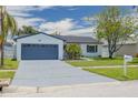 Charming single-story home featuring a well-maintained lawn, a blue painted driveway and a mailbox at 7815 Shadow Run Dr, Largo, FL 33773