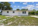 Charming single-story home featuring a fresh white exterior and cozy carport under a bright blue sky at 9259 Marler Rd, Spring Hill, FL 34608